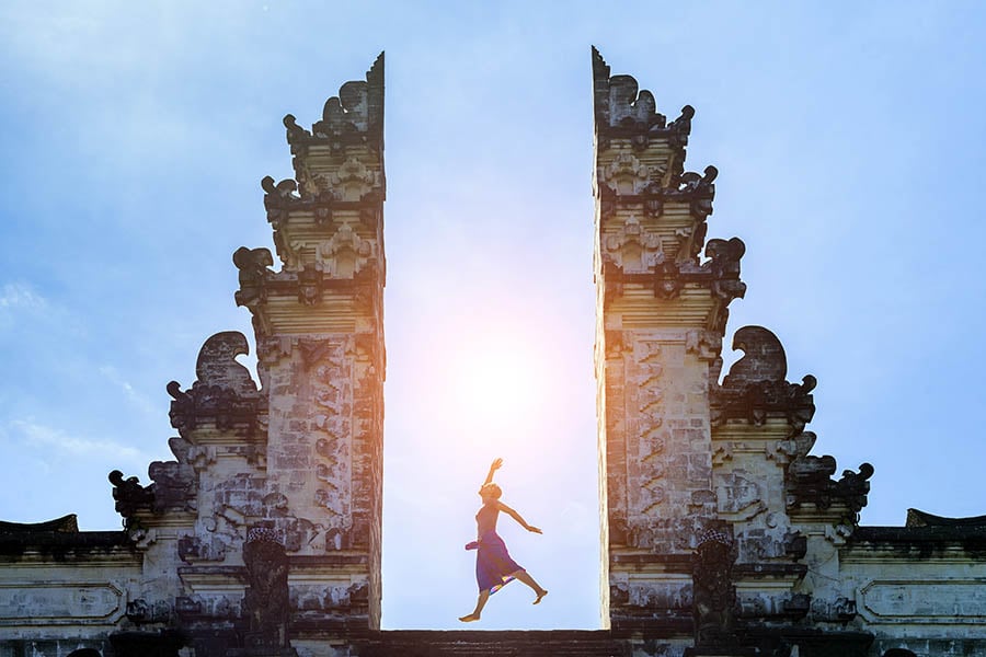 indonesia-bali-temple-woman-jumping-900x600