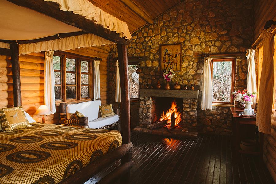 Relax by an open fire in your cosy log cabin in Mufindi Highland Lodge, Tanzania | Photo credit: Foxes Safari Camps