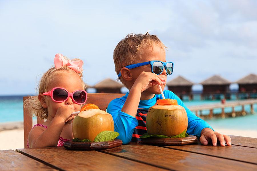 family travel kids drinking coconuts